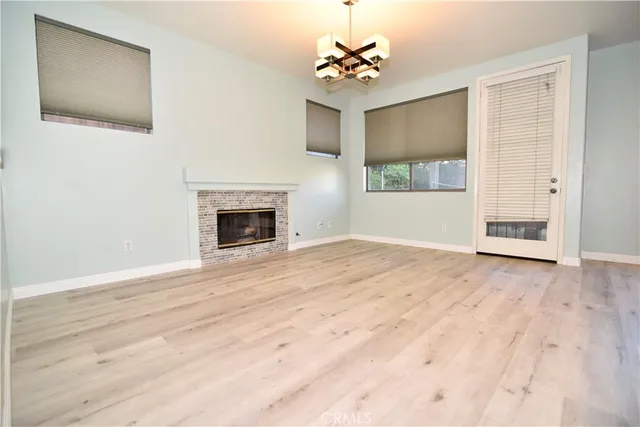 a view of an empty room with a window and fireplace