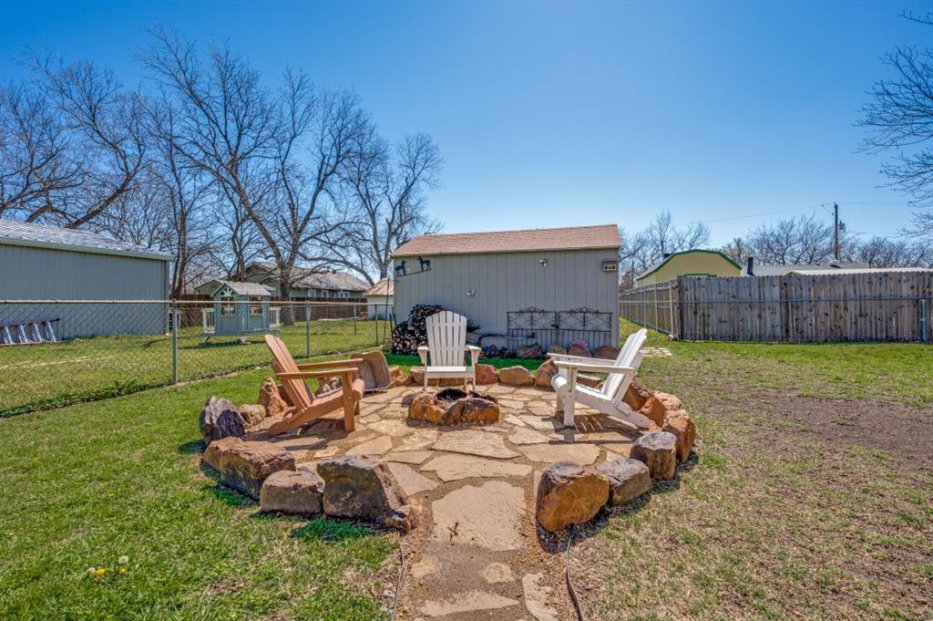 412 North 10th Street Sanger, TX 76266 - Photo 18 of 21 a view of a backyard with table and chairs potted plants and large tree