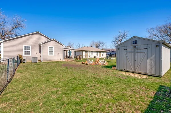 a view of a house with a yard and wooden fence