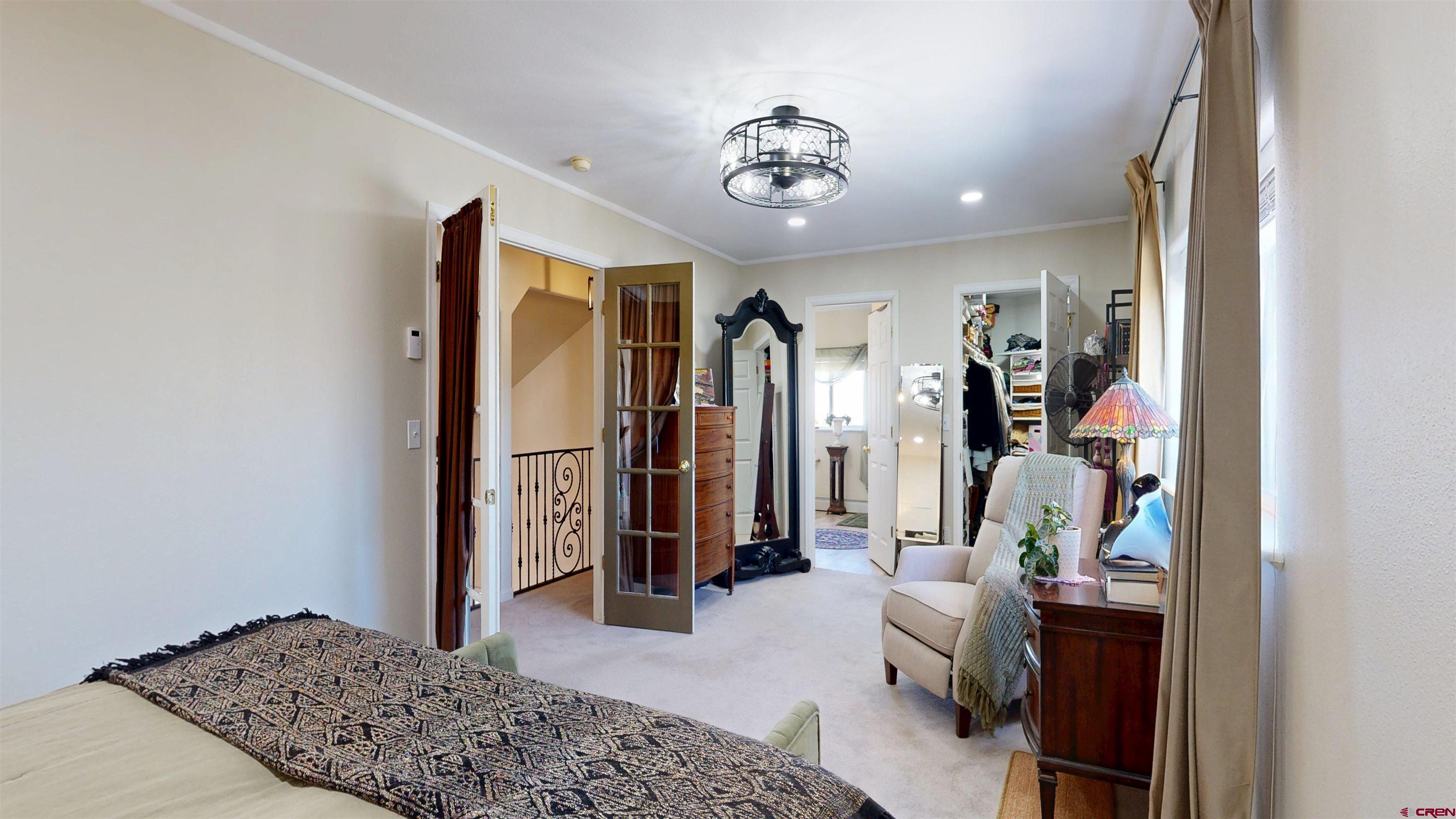 62940 Jeremy Road Montrose, CO 81401 - Photo 18 of 44 a bedroom with a bed and a chandelier