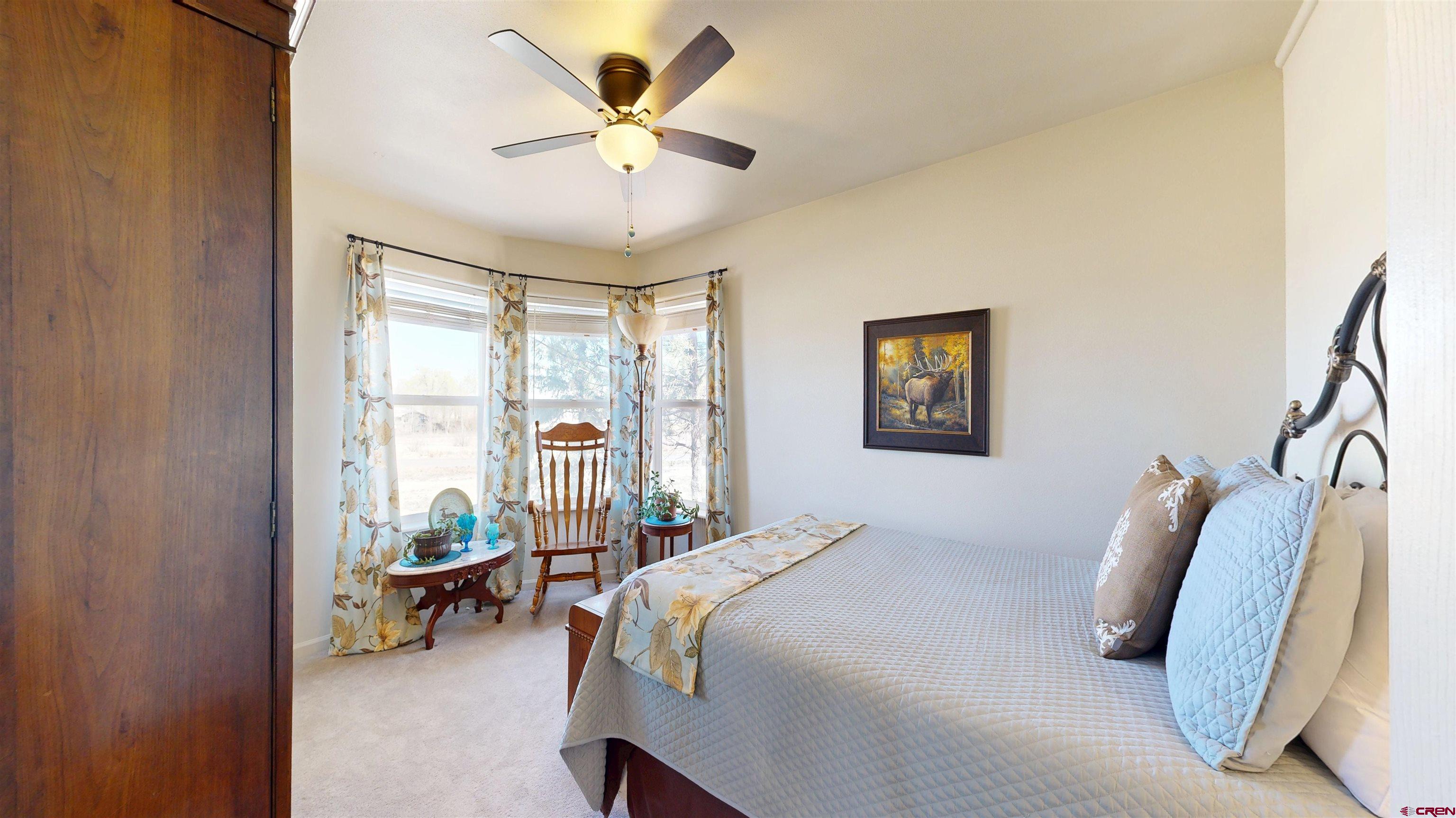 62940 Jeremy Road Montrose, CO 81401 - Photo 29 of 44 a bedroom with a bed and a chandelier