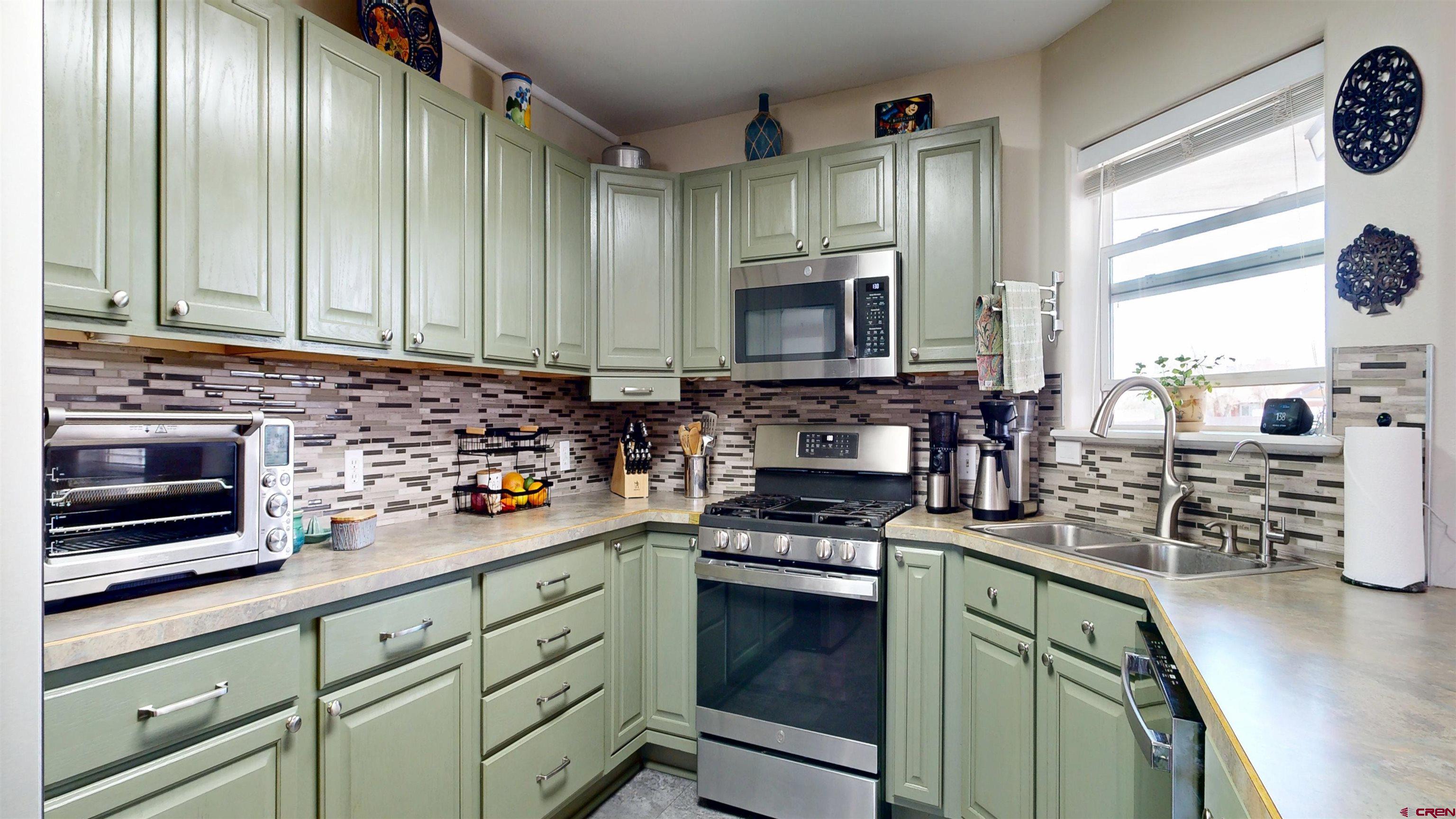 62940 Jeremy Road Montrose, CO 81401 - Photo 7 of 44 a kitchen with stainless steel appliances a stove sink microwave and cabinets