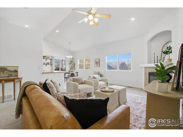 a living room with furniture a chandelier and a window
