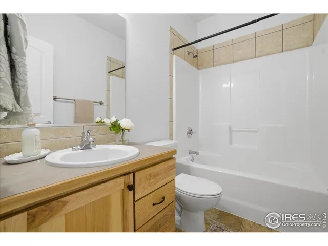 a bathroom with a granite countertop sink a toilet and shower