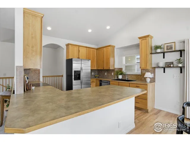 a kitchen with stainless steel appliances granite countertop a refrigerator a stove and a sink