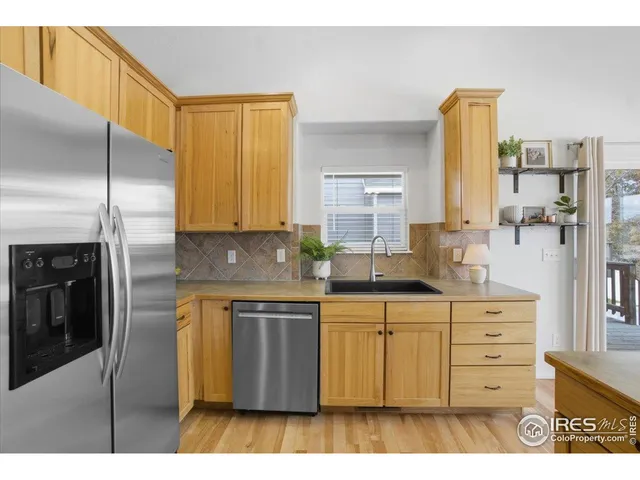 a kitchen with stainless steel appliances granite countertop a sink a stove and refrigerator