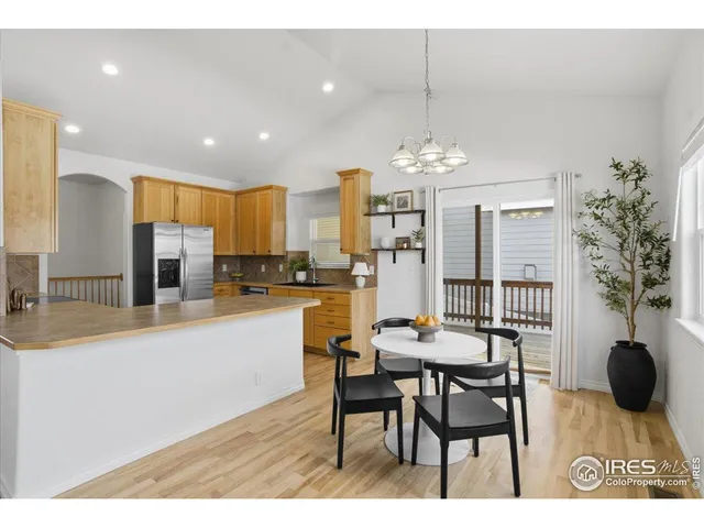 a kitchen with stainless steel appliances kitchen island granite countertop a table and chairs in it