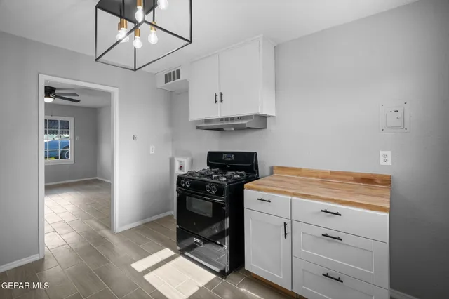 a kitchen with a stove and white cabinets