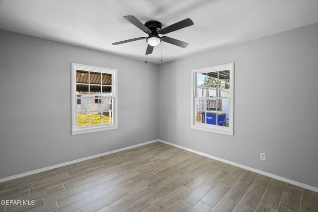 an empty room with window and ceiling fan