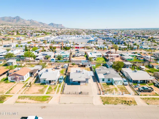 an aerial view of residential houses with a street and green space