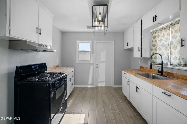 a kitchen with stainless steel appliances a sink stove and cabinets