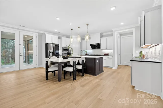 a view of an empty room with wooden floor and a fireplace