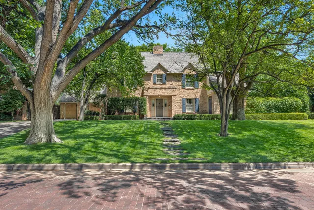 a view of a white house with a big yard and large trees