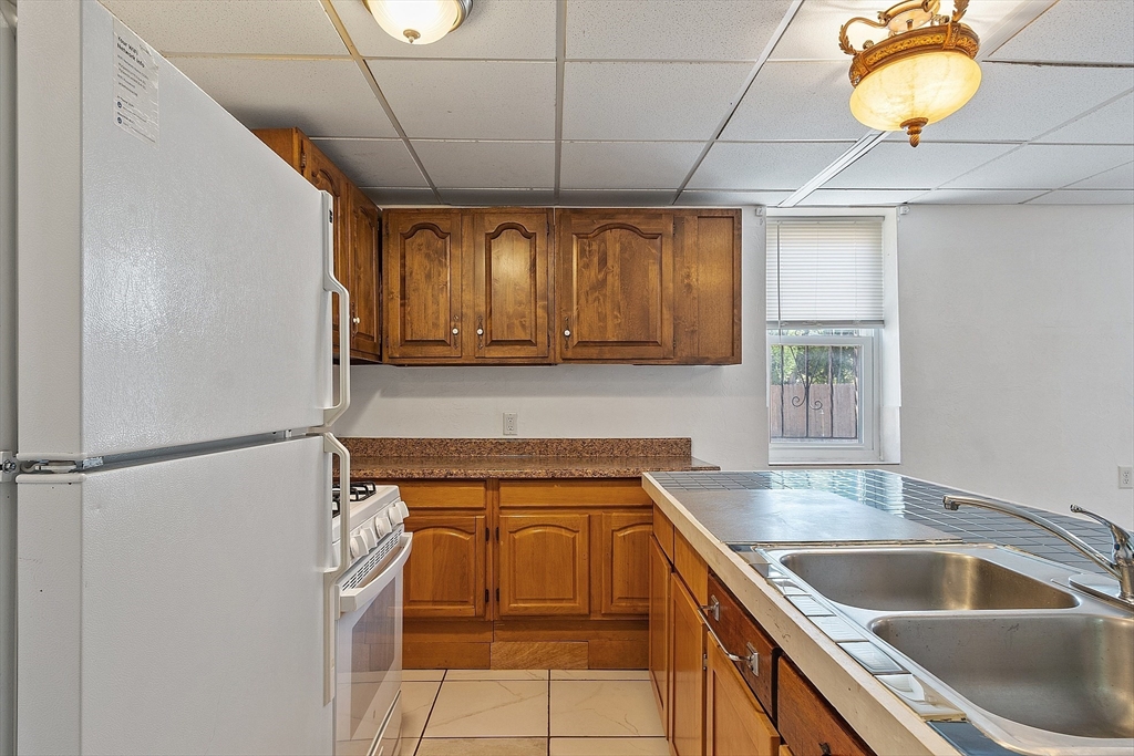 40 Aetna Street Worcester, MA 01604 - Photo 14 of 42 a kitchen with a sink a refrigerator and cabinets