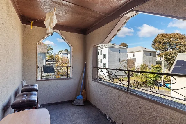 a balcony with lots of potted plants