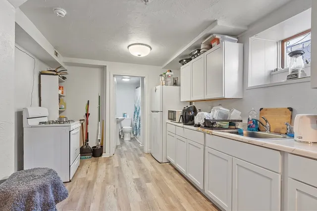a kitchen with cabinets a sink a window and stainless steel appliances