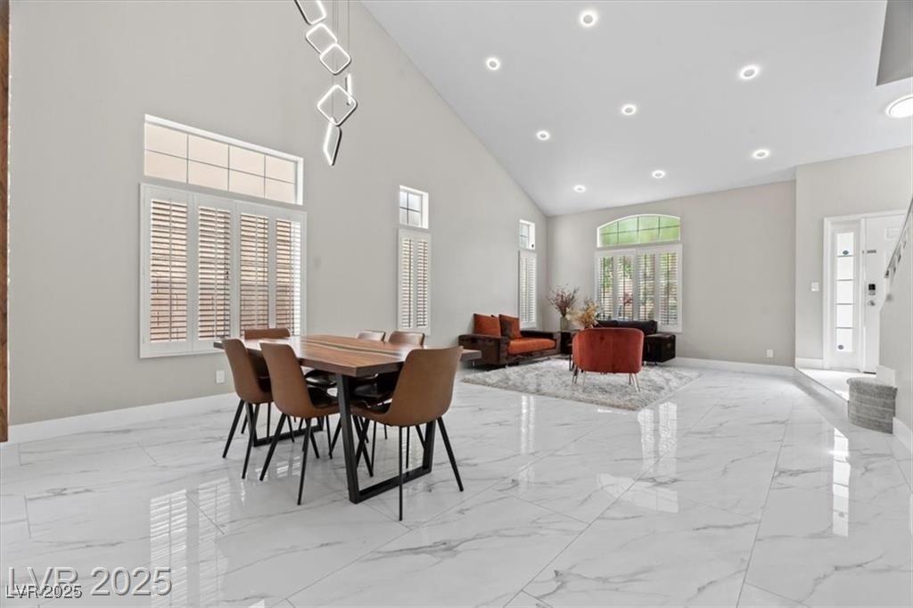 9416 Rolling Ridge Lane Las Vegas, NV 89134 - Photo 6 of 34 Dining area with high vaulted ceiling, light marble finish floors, recessed lighting, and stairway