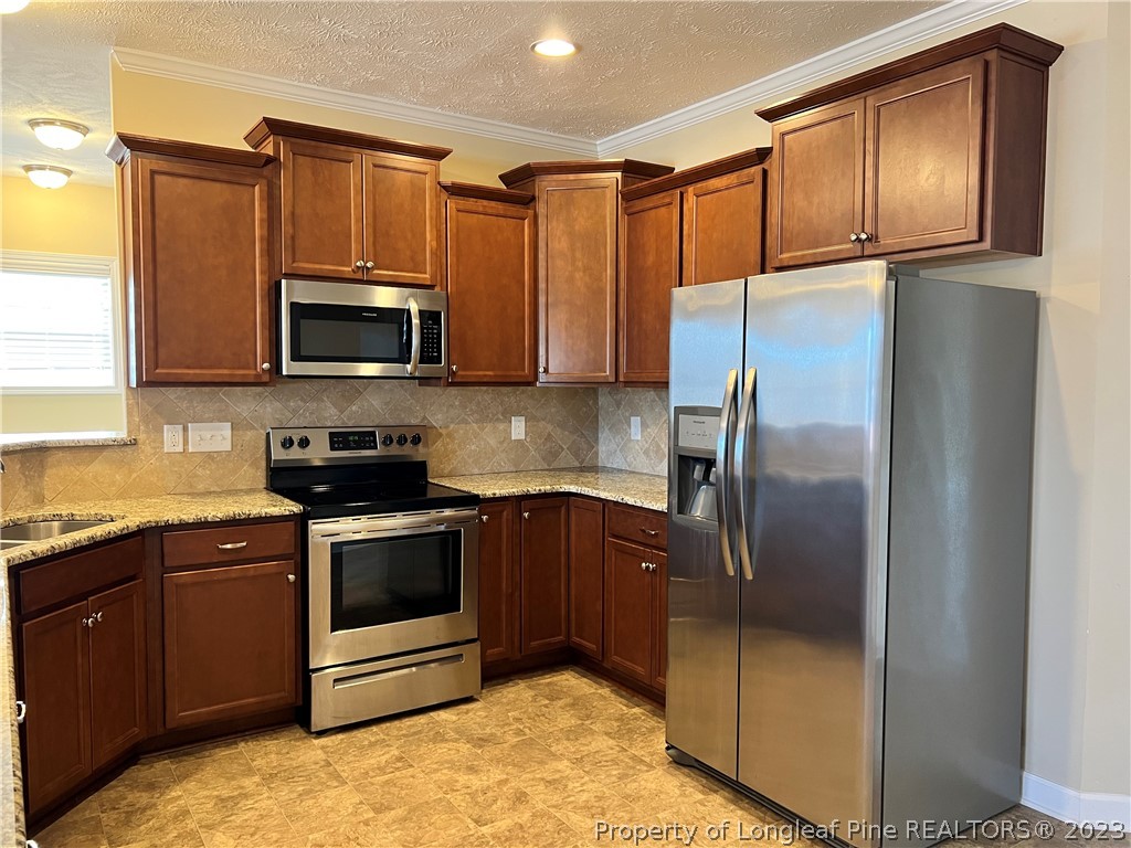 4775 McKinnon Farm Road Fayetteville, NC 28304 - Photo 14 of 45 a kitchen with granite countertop a refrigerator and a sink