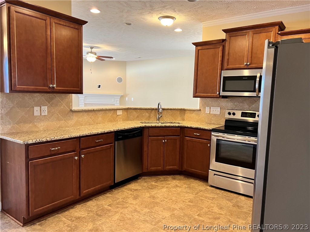 4775 McKinnon Farm Road Fayetteville, NC 28304 - Photo 15 of 45 a kitchen with granite countertop a refrigerator and a sink