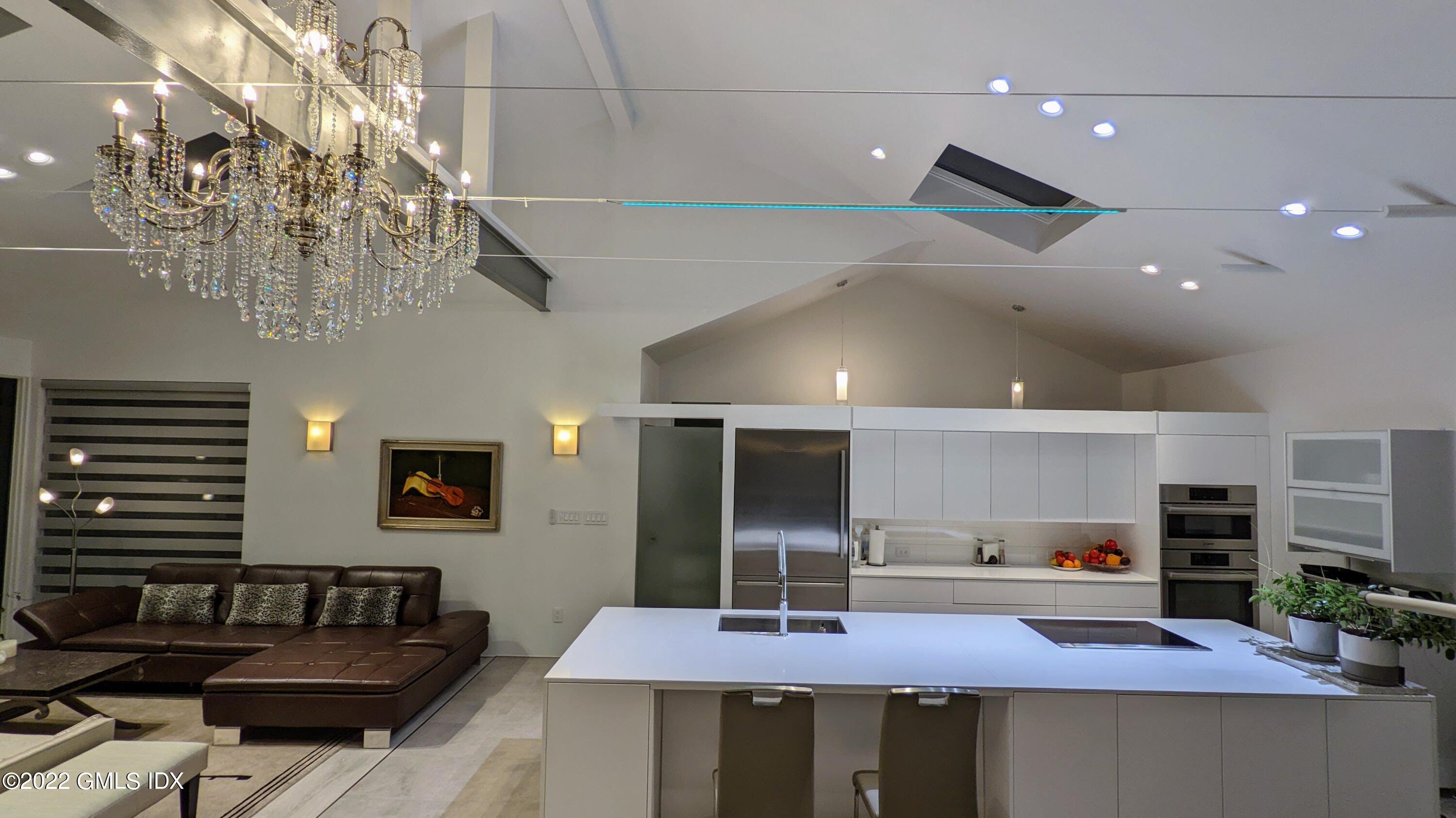 39 Nutmeg Drive Greenwich, CT 06831 - Photo 17 of 31 a kitchen with stainless steel appliances kitchen island granite countertop a table and chairs in it