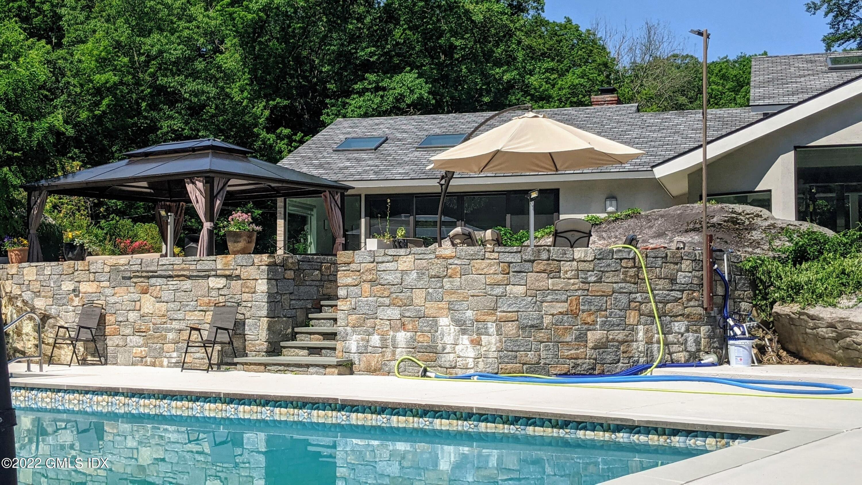 39 Nutmeg Drive Greenwich, CT 06831 - Photo 25 of 31 a backyard of a house with yard and outdoor seating