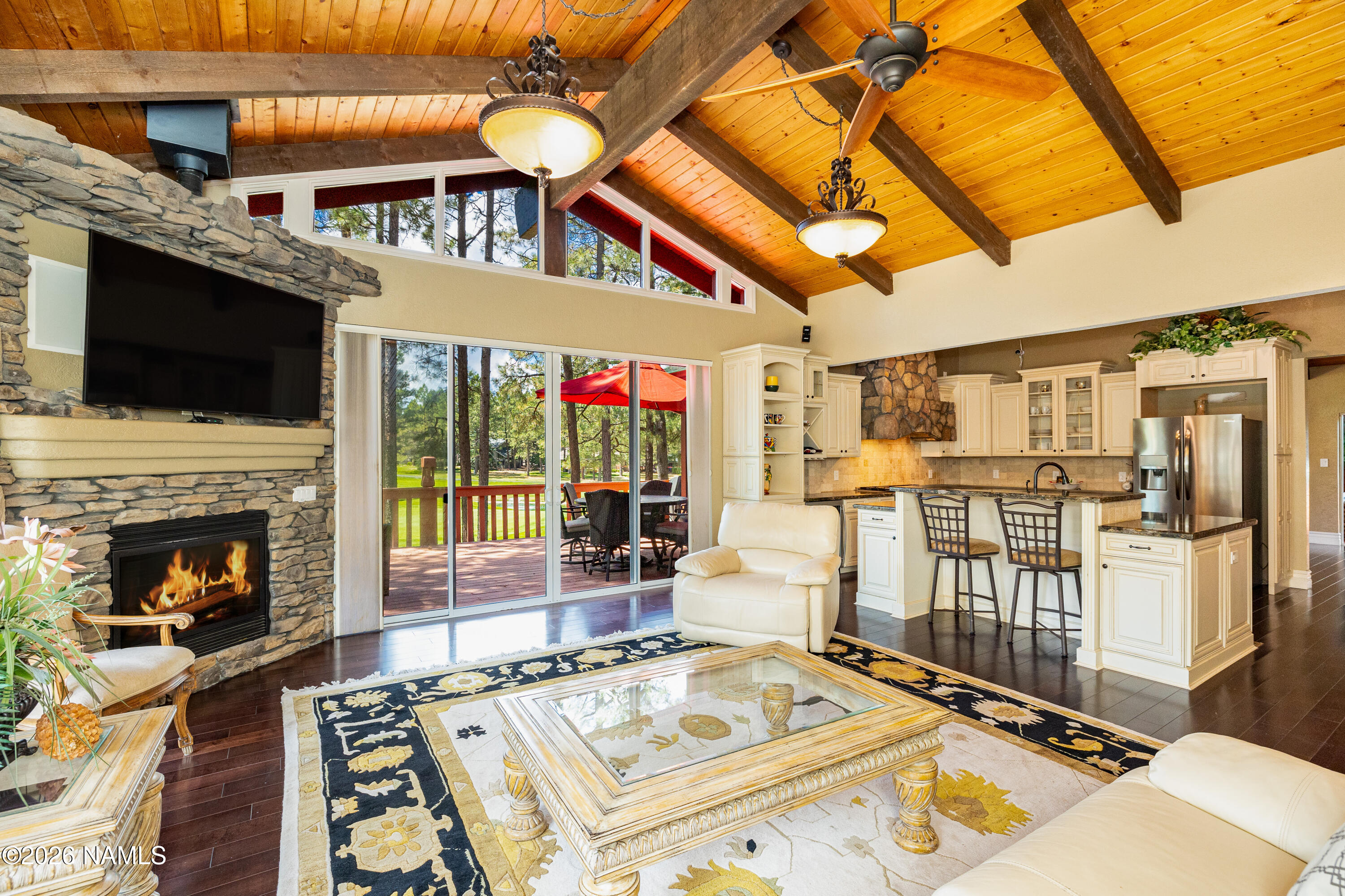 1407 North Mariposa Road Flagstaff, AZ 86004 - Photo 22 of 85 a living room with a fireplace a flat screen tv and a floor to ceiling window