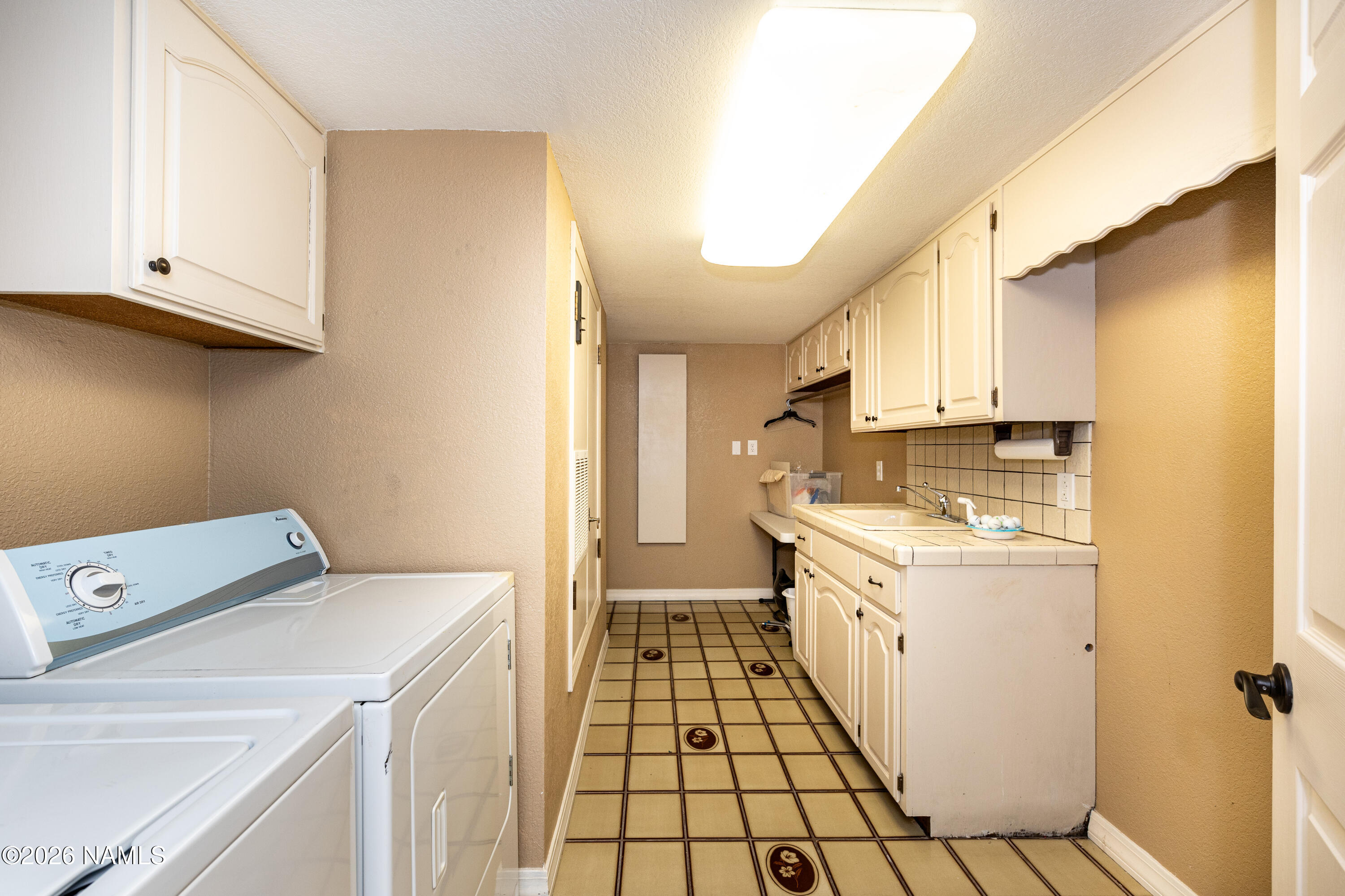 1407 North Mariposa Road Flagstaff, AZ 86004 - Photo 49 of 85 a kitchen with a sink a stove top oven and white cabinets