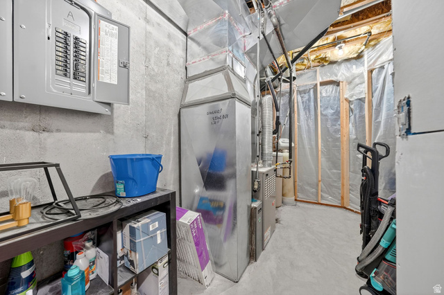 14738 Tangle Hill Road Herriman, UT 84096 - Photo 57 of 66 Unfinished basement space featuring exposed concrete walls and flooring, a visible electrical panel, and HVAC system