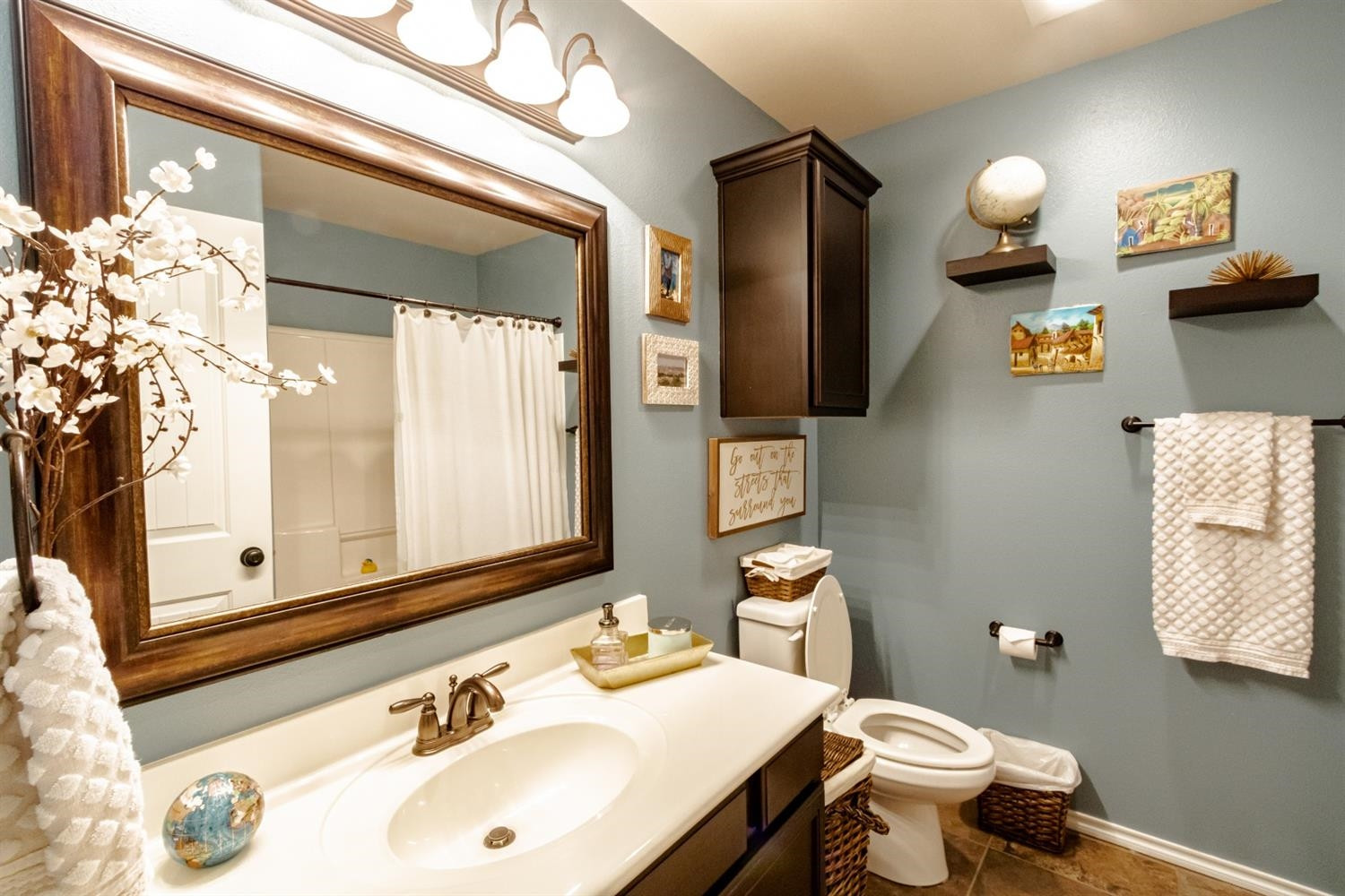 9301 Rochester Avenue Lubbock, TX 79424 - Photo 31 of 49 a bathroom with a sink vanity mirror and toilet