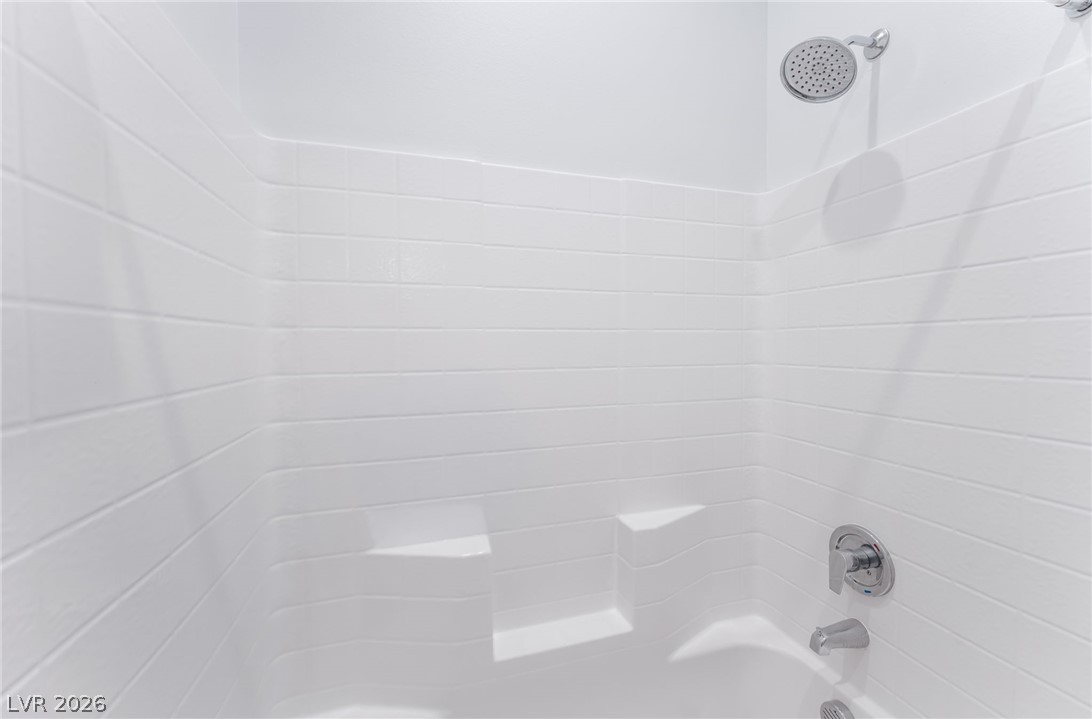 6432 Spring Jog Street Las Vegas, NV 89166 - Photo 33 of 61 A pristine white tub and shower combination awaits to refresh and rejuvenate.