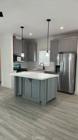 a kitchen with stainless steel appliances granite countertop a sink a stove and a refrigerator