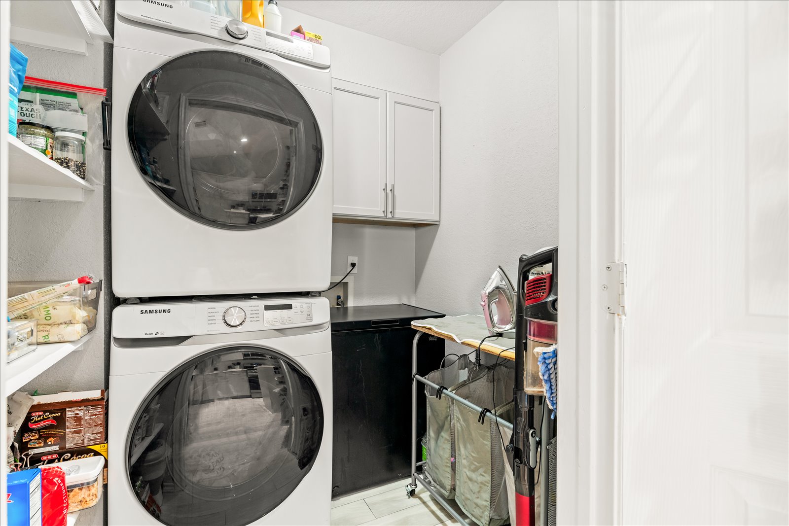 4456 Mather Kyle, TX 78640 - Photo 20 of 25 Washroom with stacked washer / drying machine, cabinet space, and light tile patterned floors