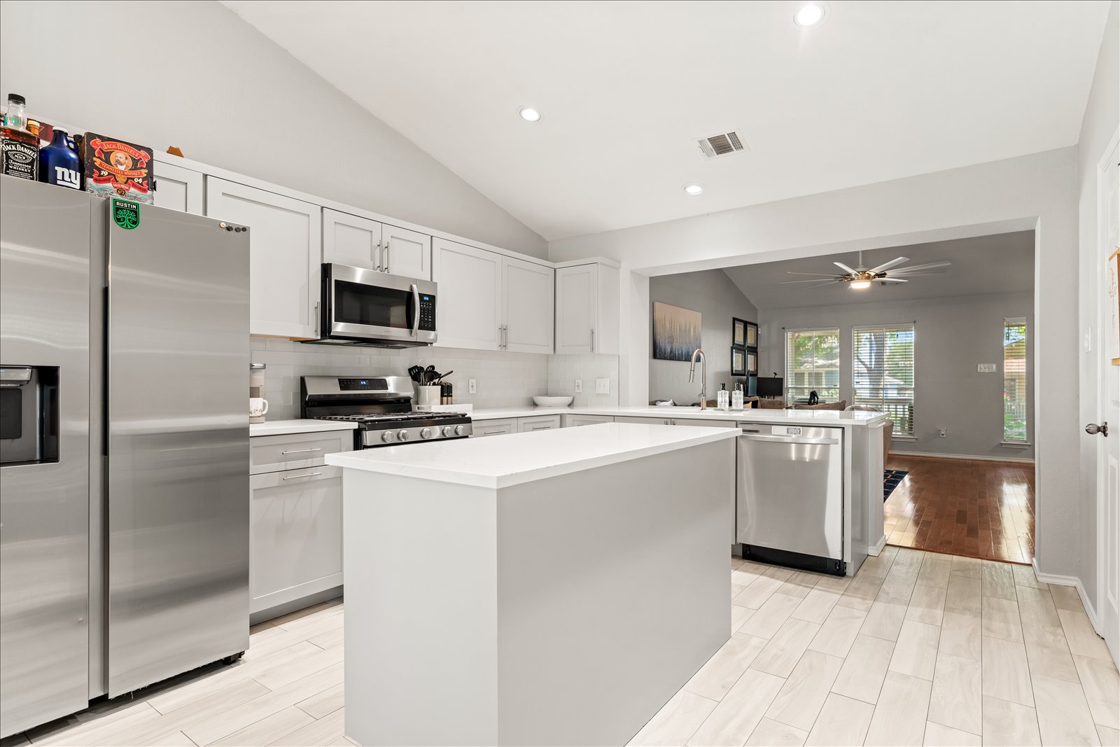 4456 Mather Kyle, TX 78640 - Photo 9 of 25 Kitchen with vaulted ceiling, stainless steel appliances, a center island, light countertops, and recessed lighting