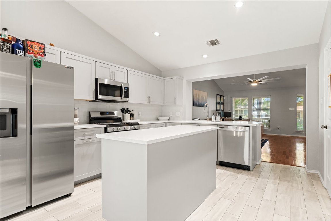 4456 Mather Kyle, TX 78640 - Photo 9 of 25 Kitchen with vaulted ceiling, stainless steel appliances, a center island, light countertops, and recessed lighting