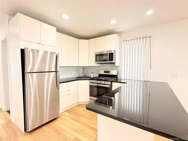 a kitchen with stainless steel appliances a refrigerator sink and microwave