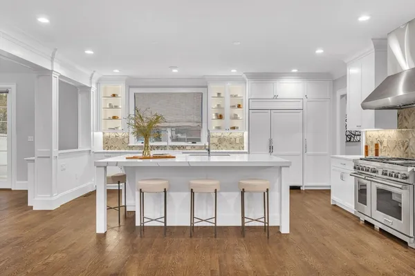 a kitchen with stainless steel appliances granite countertop a stove a sink dishwasher and a refrigerator with wooden floor