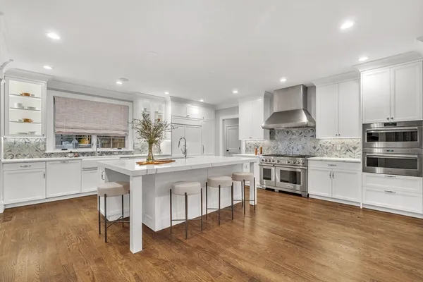 a kitchen with stainless steel appliances kitchen island granite countertop a stove a sink and a refrigerator