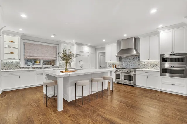 a kitchen with stainless steel appliances kitchen island granite countertop a stove a sink and a refrigerator