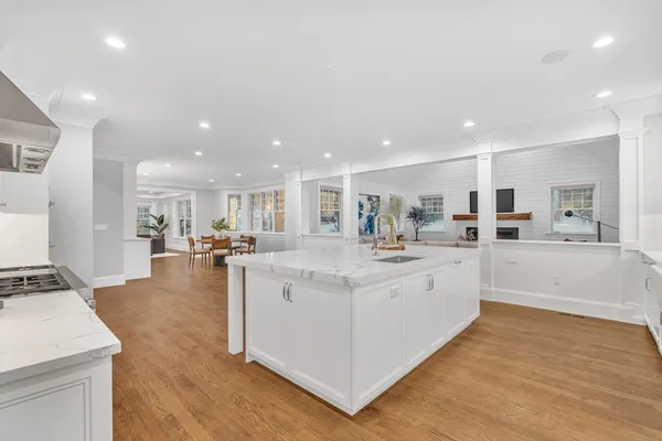 a large white kitchen with kitchen island a sink a stove and a refrigerator