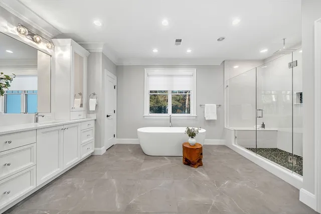 a spacious bathroom with a double vanity sink a mirror and a bathtub