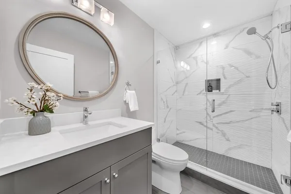 a bathroom with a sink a toilet and a mirror