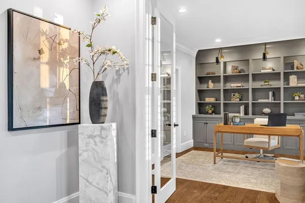 a view of a workspace with furniture and a window