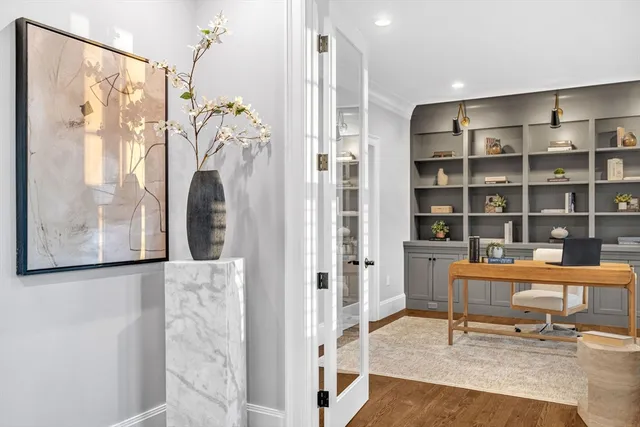 a view of a workspace with furniture and a window