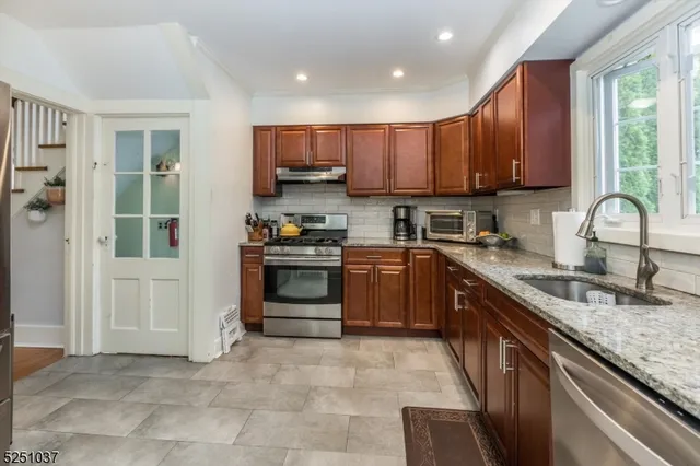 a kitchen with stainless steel appliances granite countertop a stove sink and cabinets