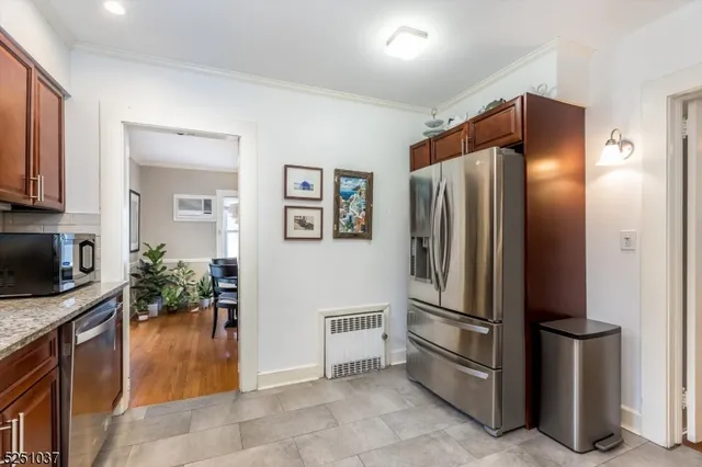 a kitchen with stainless steel appliances granite countertop a refrigerator and a stove top oven