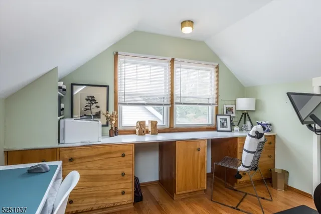 a view of a workspace with furniture and a window