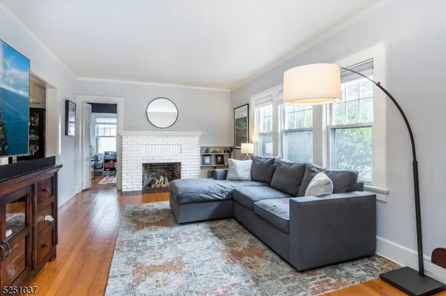 a living room with furniture a large window and a fireplace