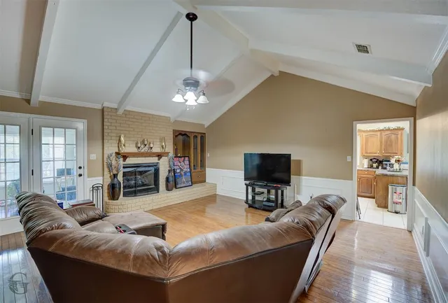 a living room with furniture a fireplace and a flat screen tv