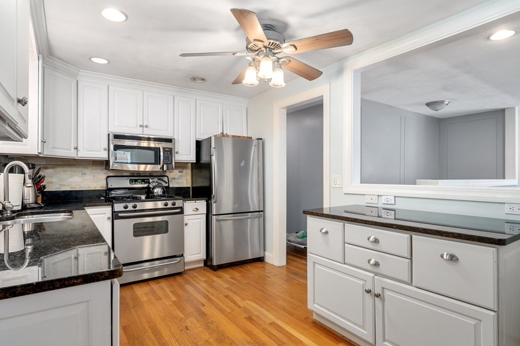 9 Bailey Lane Georgetown, MA 01833 - Photo 13 of 42 a kitchen with stainless steel appliances granite countertop a refrigerator a stove a sink and a microwave