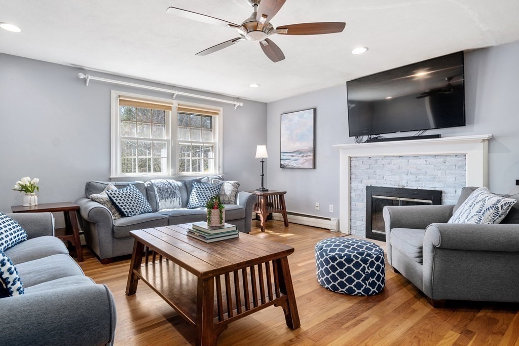 9 Bailey Lane Georgetown, MA 01833 - Photo 6 of 42 a living room with furniture a flat screen tv and a fireplace